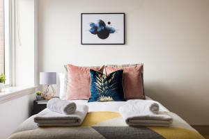 a bedroom with a bed with towels on it at The Kingston Upon Thames Apartments in London