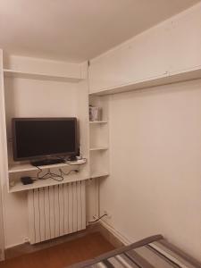 a television sitting on a shelf in a room at Maison d'ozoir in Ozoir-la-Ferrière
