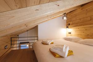 una camera da letto con un grande letto bianco e pareti in legno di Chalet Bio Corti Spa 4 personnes a Champagny-en-Vanoise