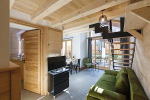 un soggiorno con divano verde e scala di Chalet Bio Corti Spa 4 personnes a Champagny-en-Vanoise