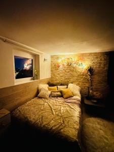 a bedroom with a bed and a brick wall at studio de charme in Perpignan