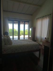 Maxaranguape的住宿－A janela do amanhecer，一间卧室设有一张床和一个大窗户