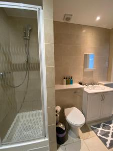 een badkamer met een douche, een toilet en een wastafel bij Stylish Central Escape in Londen