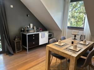 ein Esszimmer mit einem Holztisch und einer Küche in der Unterkunft B&B Des Heures Claires in Lasne