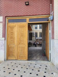 duże drewniane drzwi w budynku z cegły w obiekcie Dili Orom Hotel w mieście Buchara
