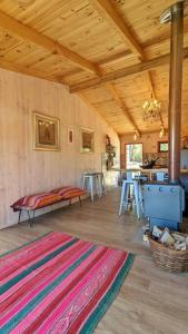 sala de estar con alfombra en el suelo de madera en ArboLodge, en Vichuquén