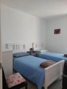 1 dormitorio con 2 camas y 1 silla en Quinto Canto Moneglia, en Moneglia