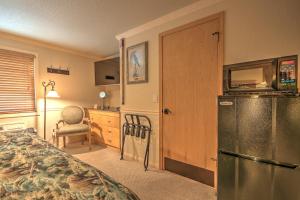 a bedroom with a refrigerator and a table and a chair at Yellowstone Gateway Inn in Gardiner