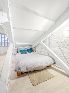 a bed in a room with a white ceiling at Le Studio des Arts in Albi