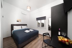- une chambre avec un lit et une table avec un bol de fruits dans l'établissement The Keratea Duet by A&D Properties, à Keratea