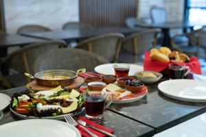 una mesa con platos de comida y bebidas. en Classio Hotel Kadıköy, en Estambul