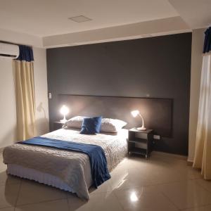 a bedroom with a large bed with two lamps on it at Hermoso Departamento - Excelente Ubicación in Ciudad del Este