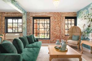 a living room with a green couch and a brick wall at The Acoma House in Denver