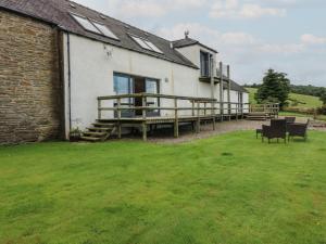 a house with a deck and a grass yard at Whitehouse Woodwrae in Forfar