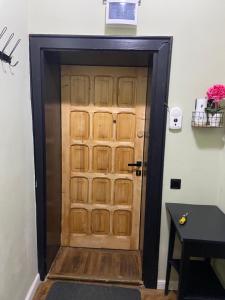 a wooden door in a hallway with a table at Green Vibes Central Brasov in Braşov