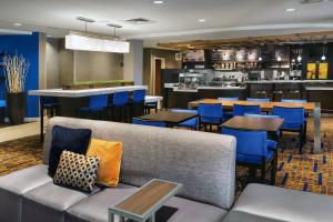 um restaurante com cadeiras e mesas azuis e um bar em Courtyard by Marriott Portland Airport em South Portland