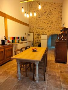 - une cuisine avec une table en bois dans une chambre dans l'établissement La Grange de Sabatas, à Chomérac