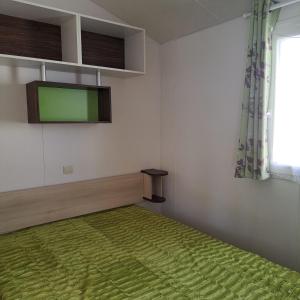 Habitación con cama y TV en la pared. en Bungalow T3 V - 15 Min From Nazaré, en Pataias