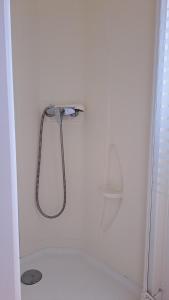 una ducha en una pared blanca con cabezal de ducha en Bungalow T3 V - 15 Min From Nazaré, en Pataias