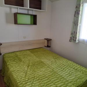 Un dormitorio con una cama con una manta verde. en Bungalow T3 V - 15 Min From Nazaré, en Pataias