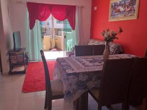 a dining room with a table with a vase of flowers on it at Imóvel com 02 quartos próxima ao Morro do Macaco in Bombinhas