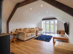 a living room with two couches and a tv at Bryn Eglwys Cottage in Tywyn