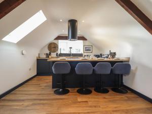 a kitchen with a black island in a loft at Bryn Eglwys Cottage in Tywyn
