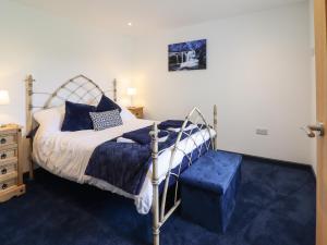 a bedroom with a bed and a blue carpet at Bryn Eglwys Cottage in Tywyn
