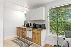 a kitchen with white cabinets and a microwave and a tree at Unit 8: Lovely updated apartment! in Billings