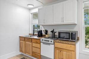 een keuken met witte kasten, een fornuis en een magnetron bij Unit 8: Lovely updated apartment! in Billings