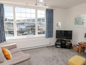 a living room with a tv and large windows at Quayside in Dartmouth