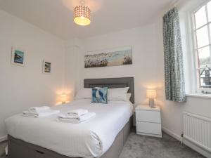 a bedroom with a bed with two towels on it at Quayside in Dartmouth