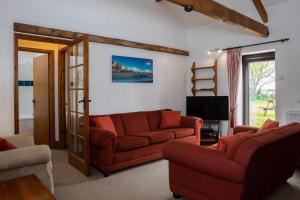 a living room with two couches and a television at Warren Cottage in Little Torrington