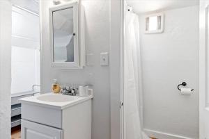 a white bathroom with a sink and a mirror at Unit 8: Lovely updated apartment! in Billings