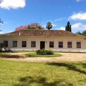 a large white building with a grass field in front of it at Pousada do sobrado in Bagé