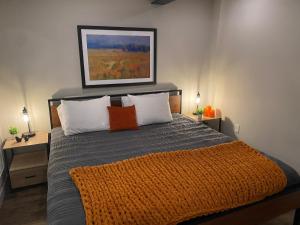 GuilfordにあるVermont Mirror Houseのベッドルーム1室(オレンジ色の毛布付きのベッド1台付)