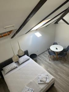 1 dormitorio con 1 cama, mesa y sillas en Apartments Ejla&Una en Mostar