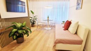 uma sala de estar com um sofá e uma mesa em Greenline by Gregory - Apartment mit Garten in Mainz, ZDF Nähe em Mainz