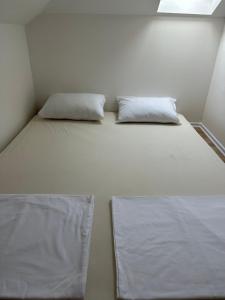2 almohadas en una cama en una habitación pequeña en Apartments Ejla&Una en Mostar