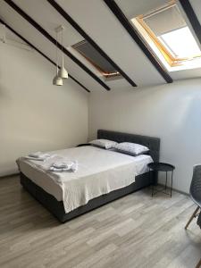 Un dormitorio con una cama y una mesa. en Apartments Ejla&Una en Mostar