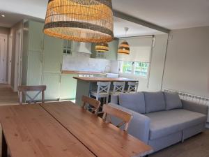 una cucina e un soggiorno con un tavolo e un divano di Casa A la orilla del Valcorba a Santibáñez de Valcorba