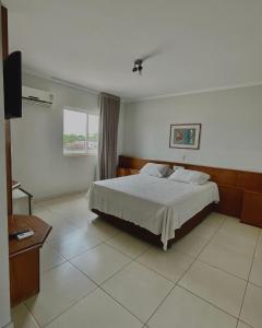 a bedroom with a bed and a television in it at Marion Pantanal Hotel in Várzea Grande