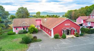 eine Luftansicht eines roten Gebäudes mit einem Parkplatz in der Unterkunft Contact Hotel Du Ladhof in Colmar