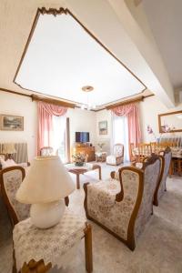 a living room with chairs and a table and a lamp at Roula's Cosy Home in Tríkala