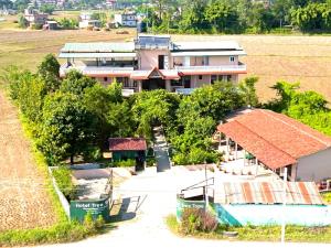 an aerial view of a house and a field at Hotel Tree Tops- A Serene Friendly Hotel in Sauraha in Chitwan