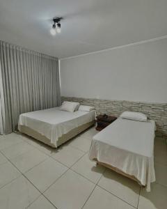 a bedroom with two beds and a wall at Marion Pantanal Hotel in Várzea Grande