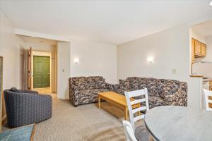 ein Wohnzimmer mit einem Sofa und einem Tisch in der Unterkunft Cedarbrook Deluxe Two Bedroom Suite with outdoor heated pool 10708 in Killington