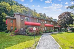 uma casa com canos vermelhos ao lado em Cedarbrook Deluxe Two Bedroom Suite with outdoor heated pool 10708 em Killington