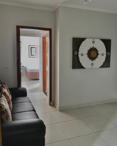 a living room with a couch and a clock on the wall at Marion Pantanal Hotel in Várzea Grande