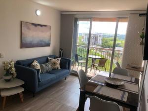 a living room with a blue couch with two dogs on it at Apartamento amoblado- Marawi 806 in Armenia